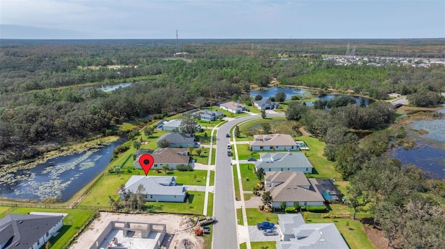 birds eye view of property featuring a water view, a wooded view, and a residential view