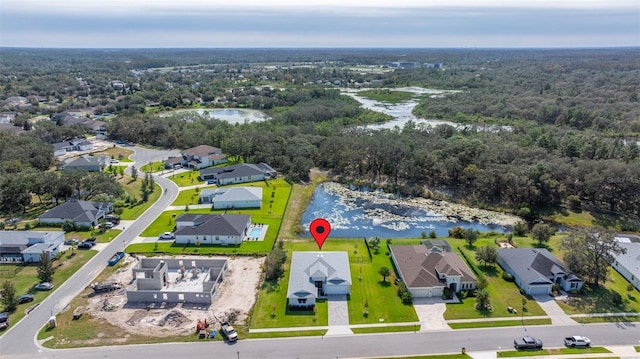 birds eye view of property with a residential view, a water view, and a wooded view