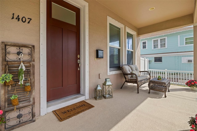 property entrance featuring covered porch and stucco siding