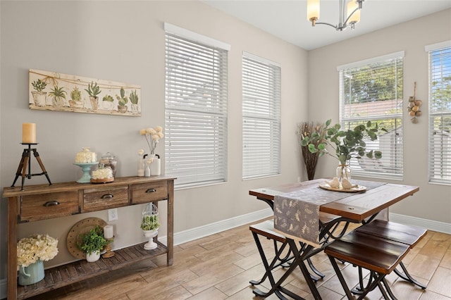 dining area with an inviting chandelier and light hardwood / wood-style flooring