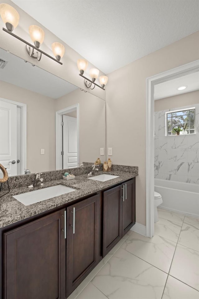 bathroom featuring a textured ceiling, vanity, and toilet