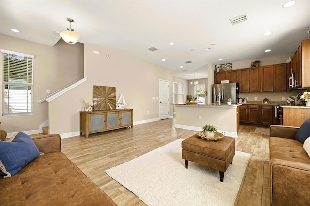 living room with baseboards, recessed lighting, visible vents, and light wood-type flooring