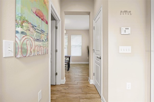 hall with baseboards and wood tiled floor