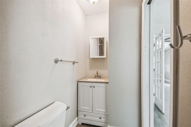 bathroom featuring toilet, hardwood / wood-style floors, and vanity