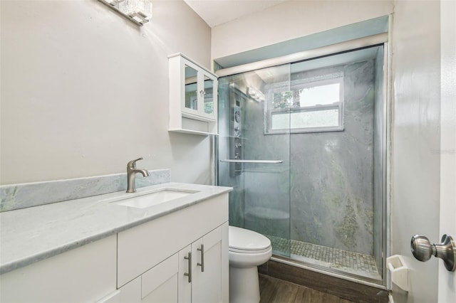 bathroom with toilet, an enclosed shower, vanity, and wood-type flooring