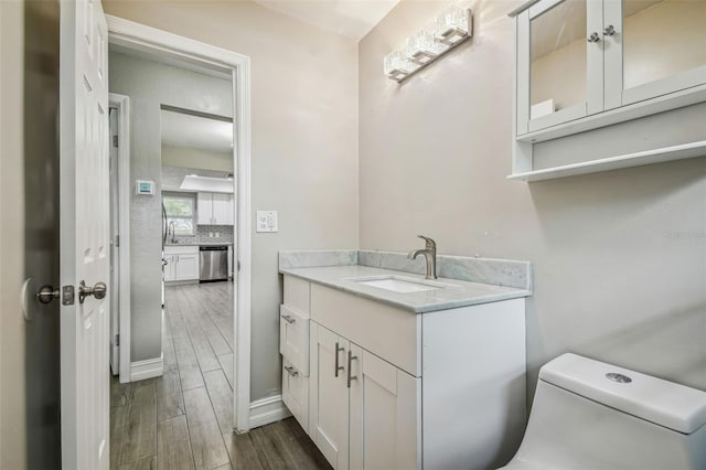 bathroom with vanity, toilet, and hardwood / wood-style floors