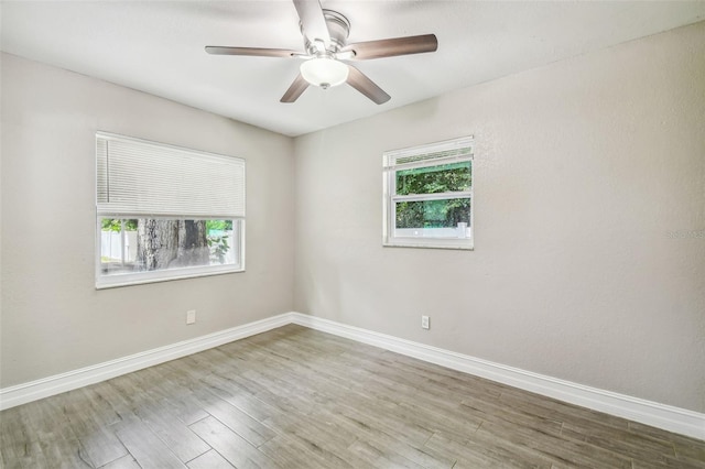 unfurnished room featuring hardwood / wood-style floors, ceiling fan, and plenty of natural light