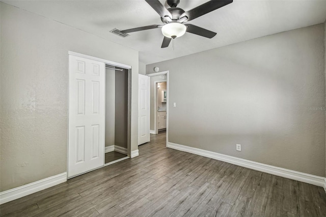 unfurnished bedroom with a closet, hardwood / wood-style flooring, and ceiling fan