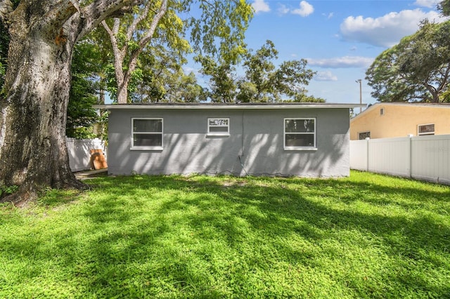 rear view of property with a yard