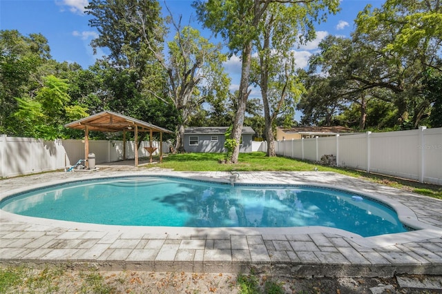 view of pool featuring a storage unit, a yard, and a patio area