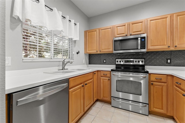 214 Cape Harbour Loop Unit 105, Bradenton, FL 34212 - kitchen with appliances with stainless steel finishes, a sink, backsplash, light tile patterned flooring, and light countertops
