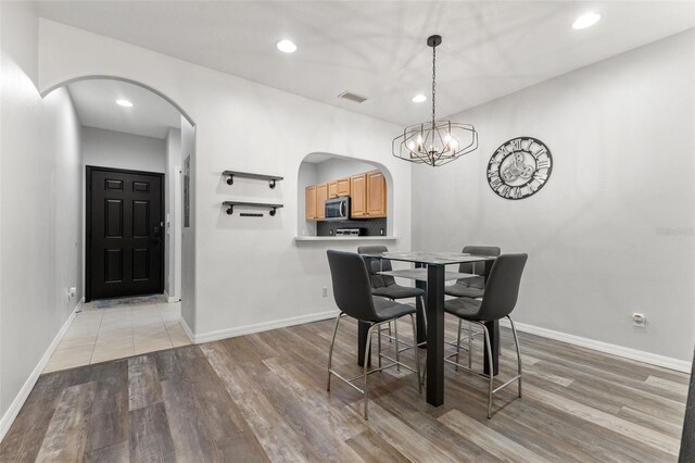 214 Cape Harbour Loop Unit 105, Bradenton, FL 34212 - dining room with arched walkways, light wood-type flooring, a chandelier, baseboards, and recessed lighting