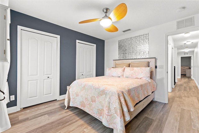 214 Cape Harbour Loop Unit 105, Bradenton, FL 34212 - bedroom with two closets, light wood-style flooring, baseboards, and a ceiling fan