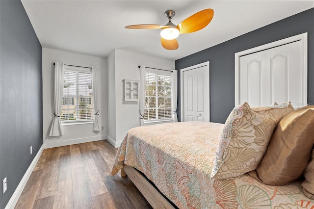 214 Cape Harbour Loop Unit 105, Bradenton, FL 34212 - bedroom with baseboards, wood finished floors, two closets, and a ceiling fan