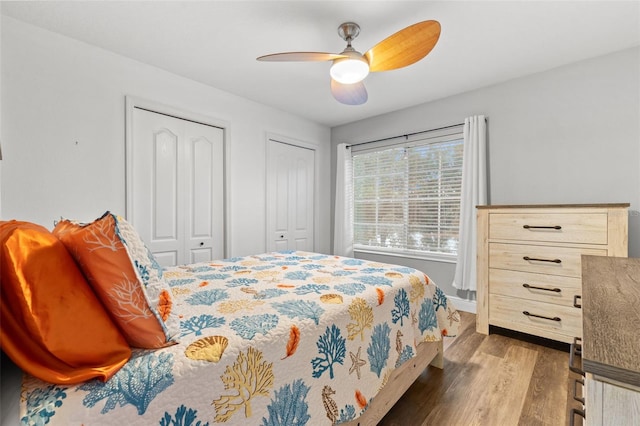 214 Cape Harbour Loop Unit 105, Bradenton, FL 34212 - bedroom featuring two closets, dark wood finished floors, baseboards, and a ceiling fan