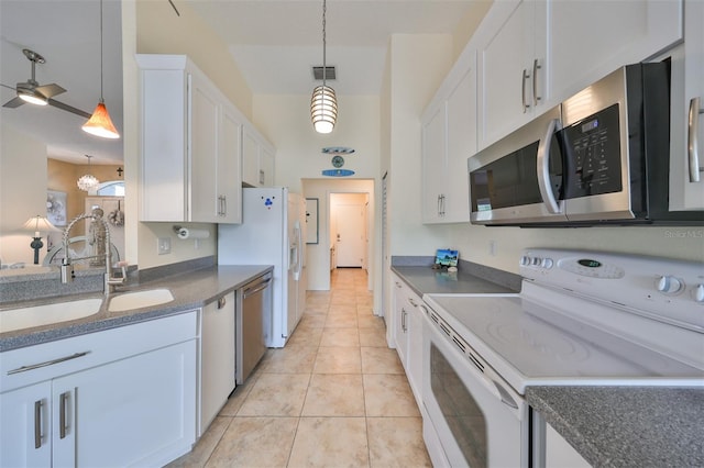 kitchen featuring appliances with stainless steel finishes, sink, light tile patterned flooring, decorative light fixtures, and white cabinets