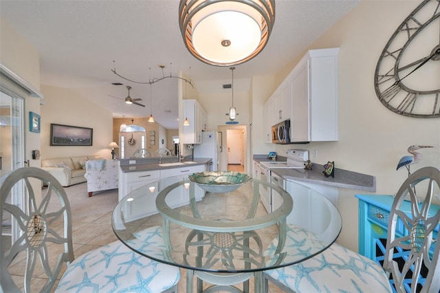 tiled dining area with sink, vaulted ceiling, and ceiling fan