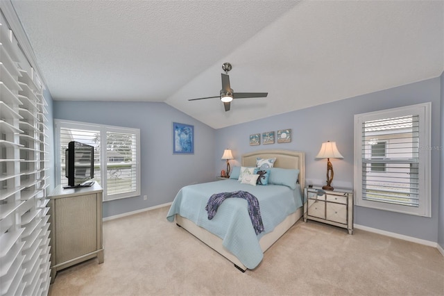 carpeted bedroom with ceiling fan, a textured ceiling, and vaulted ceiling