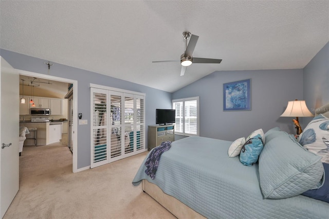 bedroom featuring ceiling fan, a textured ceiling, vaulted ceiling, and light colored carpet