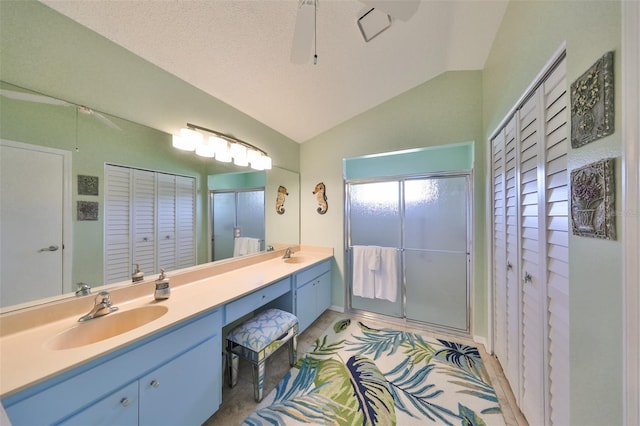 bathroom featuring a textured ceiling, a shower with shower door, ceiling fan, vaulted ceiling, and vanity