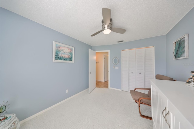 home office featuring ceiling fan, a textured ceiling, and light colored carpet