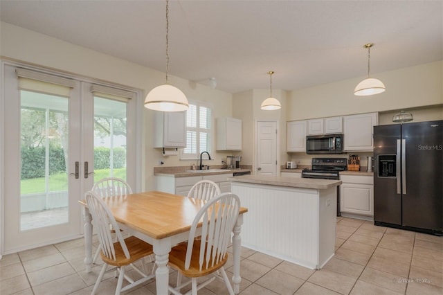 kitchen featuring white cabinets, hanging light fixtures, a kitchen island, and black appliances