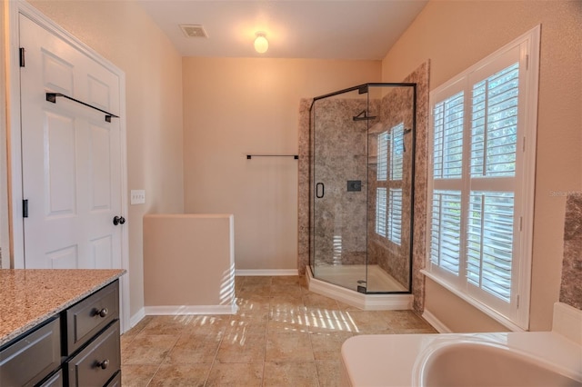 bathroom with a shower with door, vanity, and tile patterned flooring