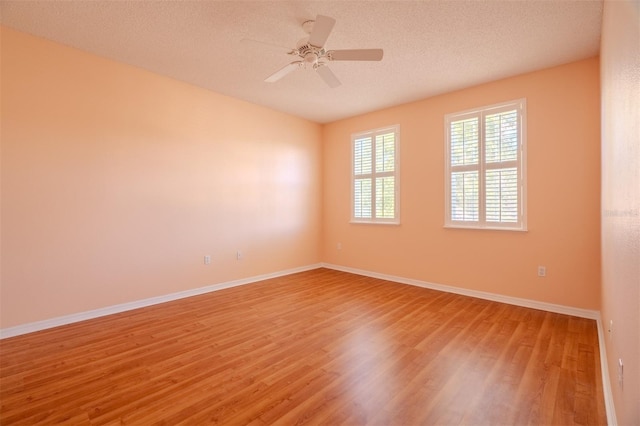 spare room featuring hardwood / wood-style floors, ceiling fan, and a textured ceiling