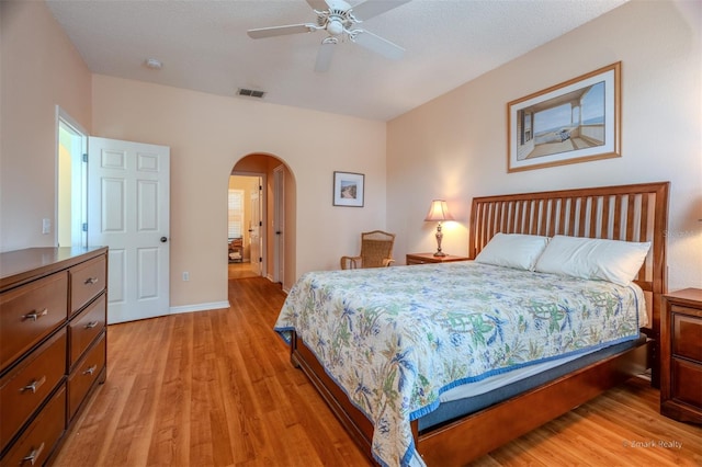 bedroom with ceiling fan, light hardwood / wood-style floors, and a textured ceiling