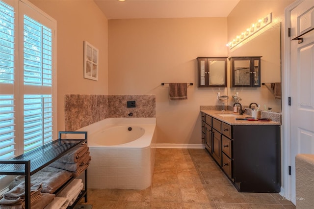 bathroom featuring tile patterned floors, vanity, and tiled tub