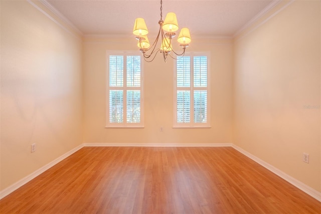 empty room with a chandelier, hardwood / wood-style flooring, and ornamental molding