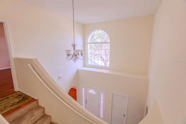 stairs featuring a chandelier and wood-type flooring