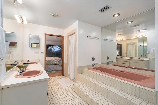 bathroom with vanity, tiled bath, and tile patterned floors