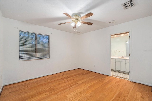 unfurnished bedroom featuring ensuite bath, ceiling fan, light hardwood / wood-style flooring, and sink