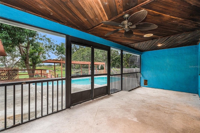 unfurnished sunroom featuring ceiling fan, lofted ceiling, and wood ceiling