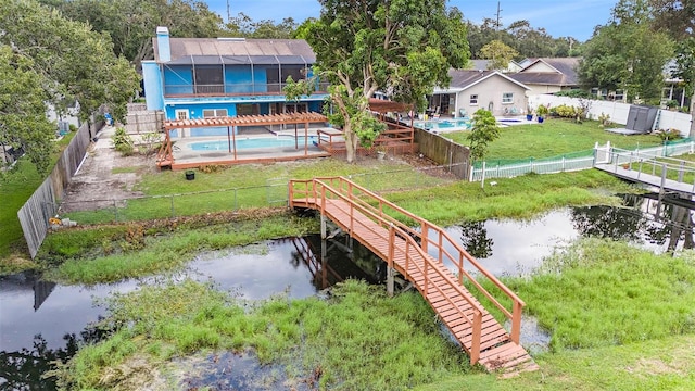 exterior space with a fenced in pool, a water view, and a lanai