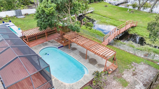 view of swimming pool featuring a patio area, a yard, and a water view