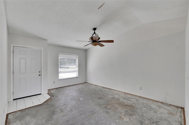 empty room with vaulted ceiling, a textured ceiling, and ceiling fan