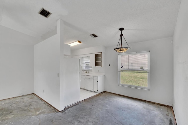 kitchen with white appliances, hanging light fixtures, a textured ceiling, and white cabinets