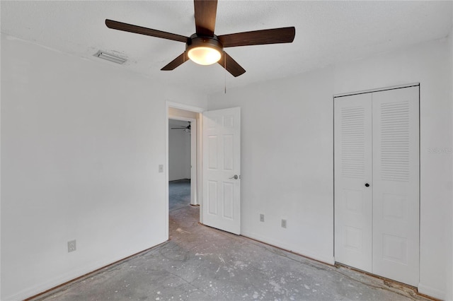 unfurnished bedroom with concrete floors, a textured ceiling, a closet, and ceiling fan