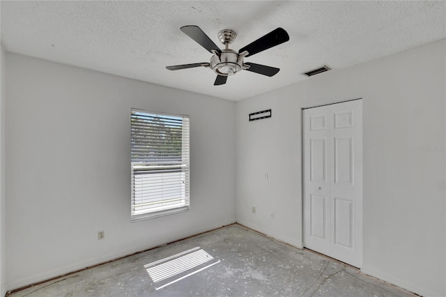 interior space with a closet, ceiling fan, and a textured ceiling