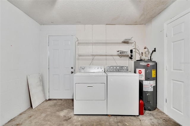 clothes washing area with water heater, a textured ceiling, and washer and clothes dryer