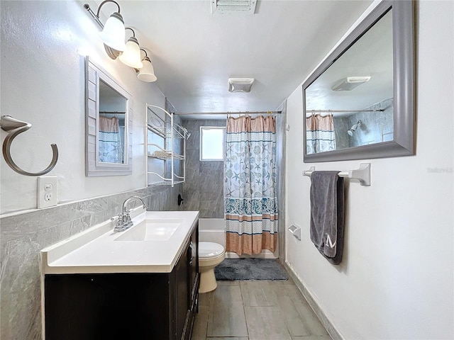 full bathroom with shower / bathtub combination with curtain, visible vents, toilet, tile walls, and vanity