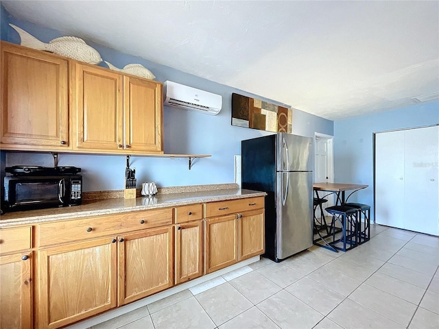 kitchen featuring an AC wall unit, light tile patterned flooring, light countertops, and freestanding refrigerator