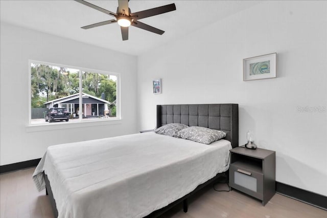 bedroom with light hardwood / wood-style floors and ceiling fan