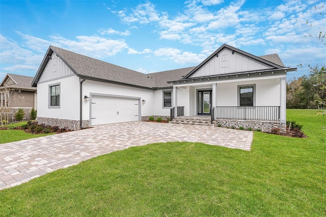 modern inspired farmhouse with decorative driveway, a garage, a front yard, board and batten siding, and covered porch