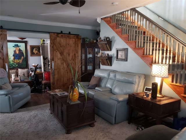 living room with ceiling fan, hardwood / wood-style flooring, crown molding, and a barn door