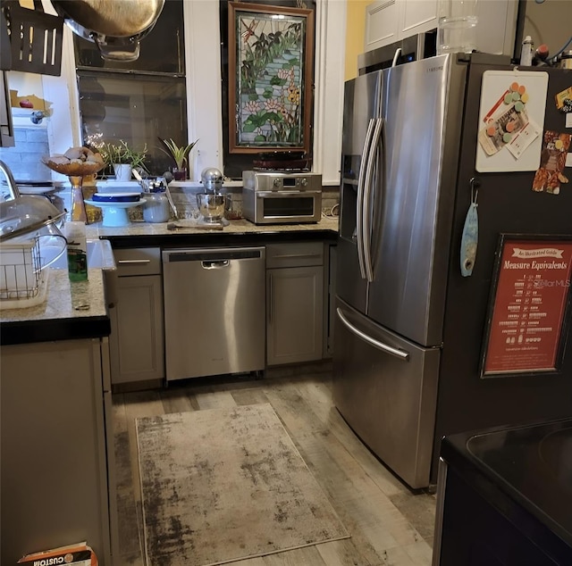 kitchen featuring light hardwood / wood-style flooring, stainless steel appliances, and gray cabinetry