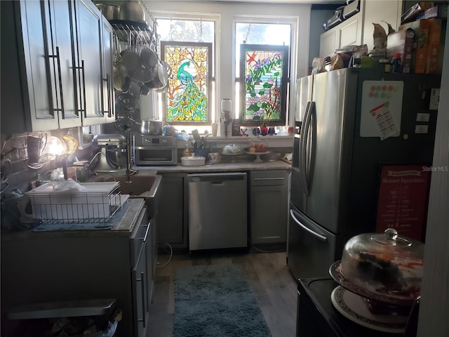 kitchen featuring stainless steel appliances, light wood-type flooring, and gray cabinetry