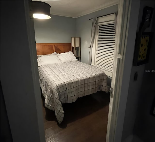 bedroom with ornamental molding and hardwood / wood-style flooring